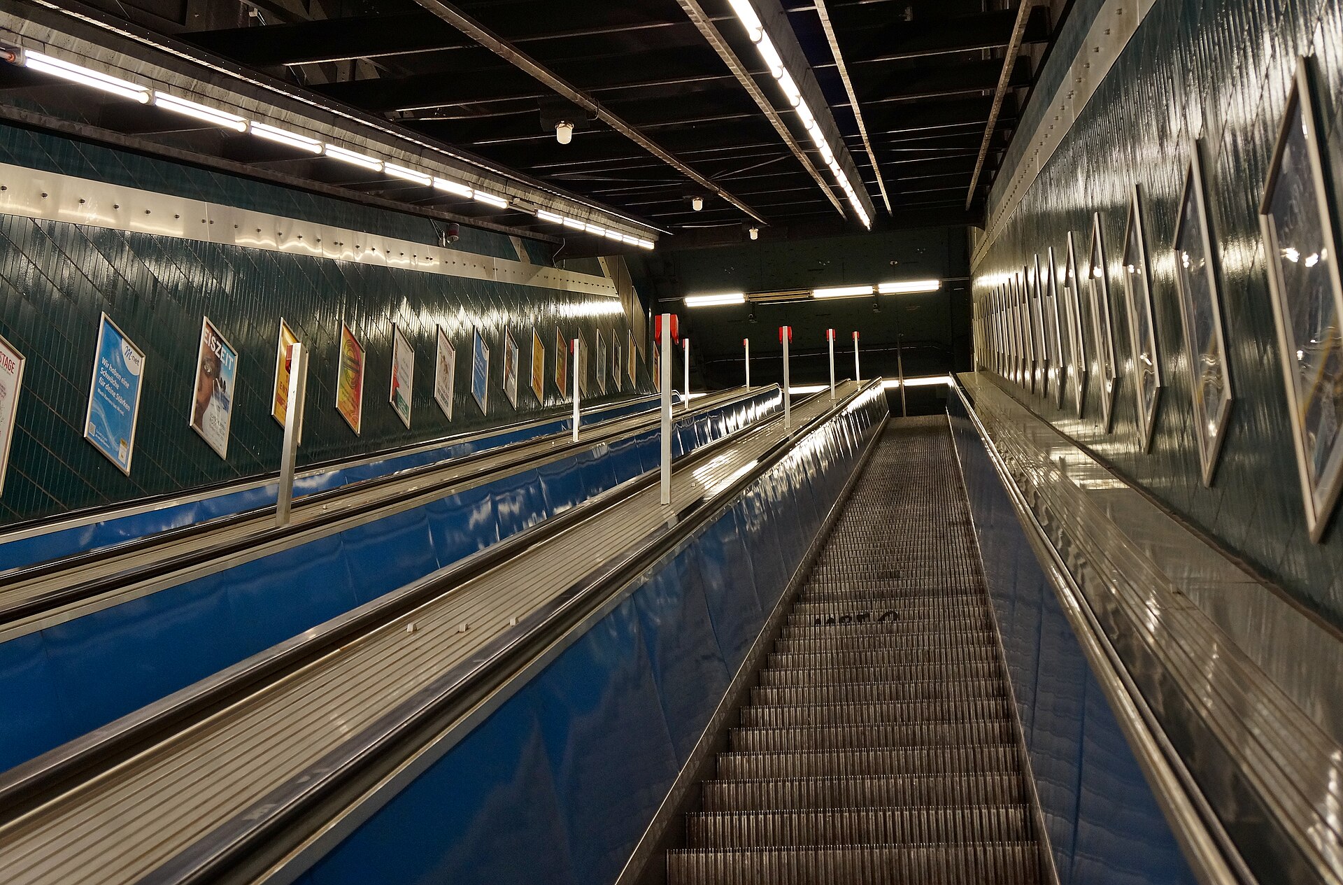 Escaleras mecánicas y pasillos azules de la estación Marienplatz del U-Bahn de Múnich.